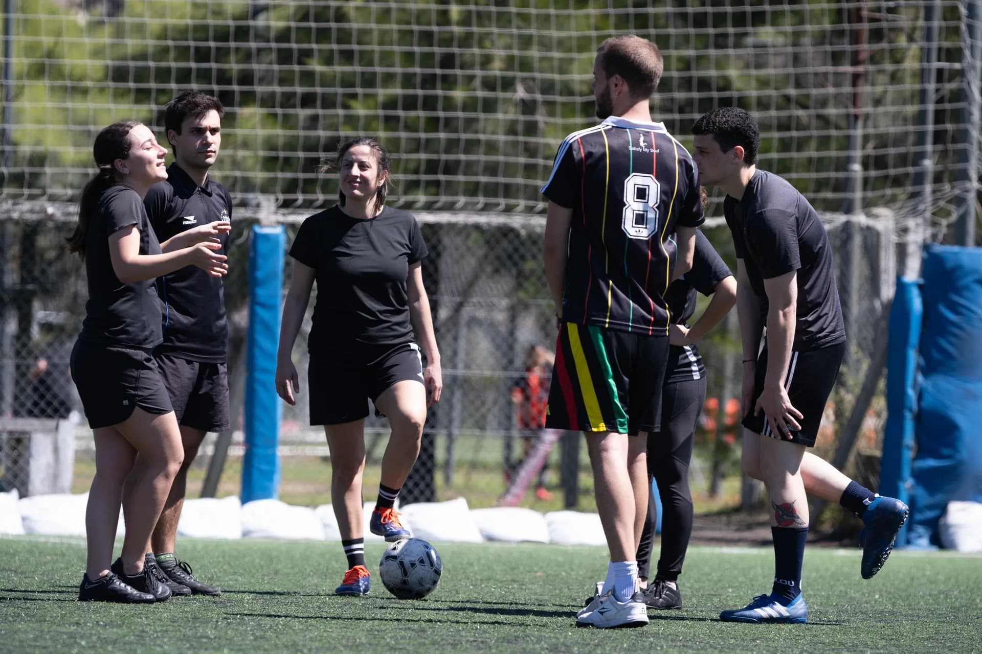 Jugadores y jugadoras conversando en la cancha